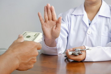 Cropped image of female doctor refusing to take bribe from patient man in corruption and bribe in...