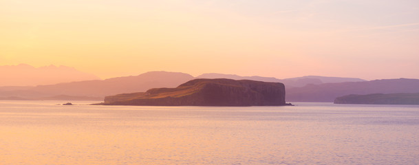 Fototapeta premium Isle of Skye Sunrise - golden sun glow on ocean, mountains and islands