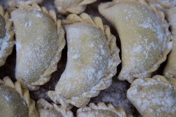 Vareniks are sprinkled with flour on the tray