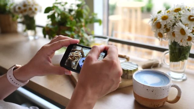 Woman Hands Taking Photo Of Vegan Desserts And Trendy Blue Matcha Latte Using Smartphone.