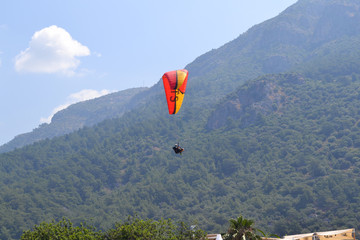 Alone paraglider flying in the blue sky against the background of clouds. Paragliding in the sky on...