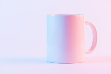 White ceramic coffee mug against pink backdrop