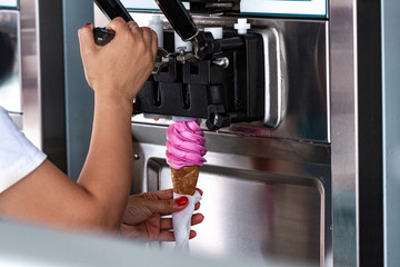 Preparation of sweet refreshing ice cream from ice cream machine during summer day