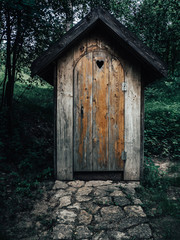Fototapeta na wymiar Old wooden restroom in a forest