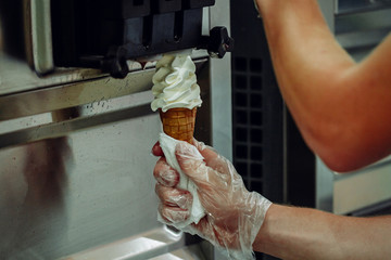 Preparation of creamy ice cream from ice cream machine in shopping center