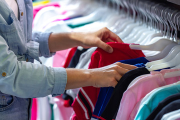 Buying casual clothes on second hand market in store. Shopping in fashion mall, choosing new...