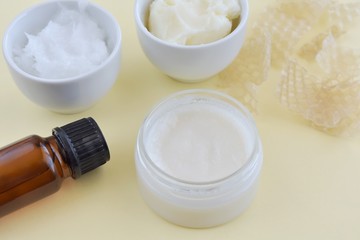 Natural homemade lip balm in small container and ingredients, coconut oil, essential oil, bee wax, shea butter, home cosmetic.