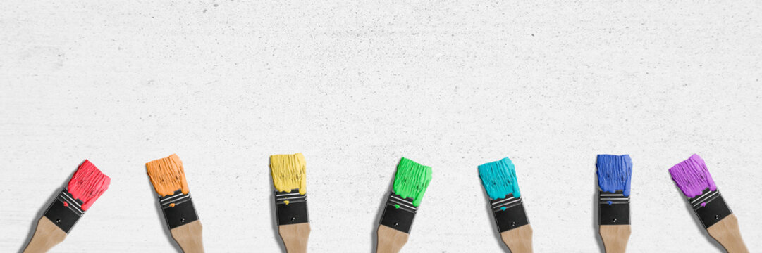brushes with different colors on white wall background