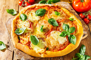 Homemade pizza with mozzarella on wooden background