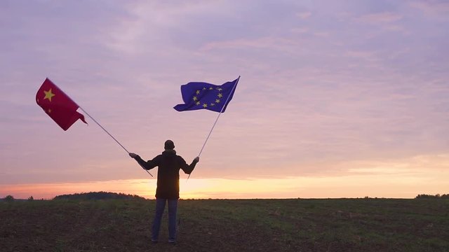 Footage of EU and Chinese flags blowing in the wind. waving flags in a landscape. EU China Flag.