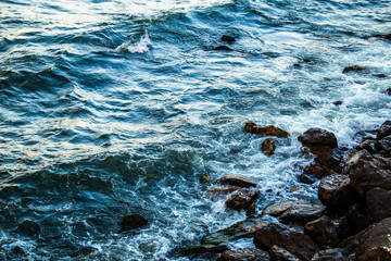 Waves hitting to the rock on a sea coast at evening