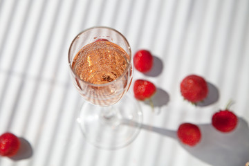 a glass of champagne with strawberries on a white background