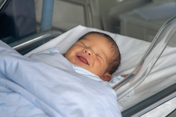 Niño recién nacido sonriendo en su cuna