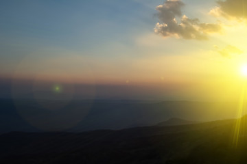 Sunset sky background or sun light in clouds in the form of tracks.  Clouds the form of long orange stripes on the sky. Dramatic valley sky sunrise mountain landscape,.
