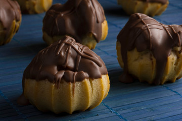 Traditional type of Brazilian profiterolis bakery candy called carolina in a blue background