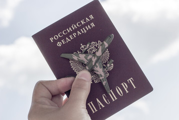 Travel concept, copy space. Airplane, passport  in female hand on blue sky background.