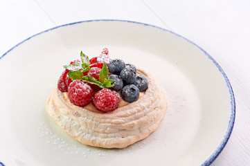 meringue nest with blueberry and raspberry. Sweet dessert