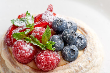 meringue nest with blueberry and raspberry. Sweet dessert