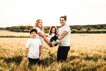 Portrait of a happy and beautiful family playing in the countryside. Family having fun