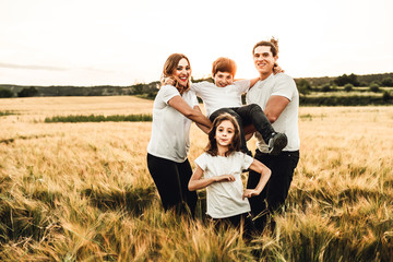 Portrait of a happy and beautiful family playing in the countryside. Family having fun