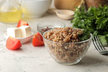 Buckwheat. Porridge cereals in a glass plate on a bright table. breakfast, healthy food.
