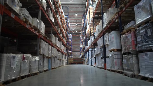 Logistics warehouse. Camera in motion. On the shelves are flying with goods. 4K Slow Mo