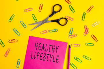 Handwriting text writing Healthy Lifestyle. Conceptual photo Live Healthy Engage in physical activity and exercise Blank colored paper sheet scissors pencil clips light color background