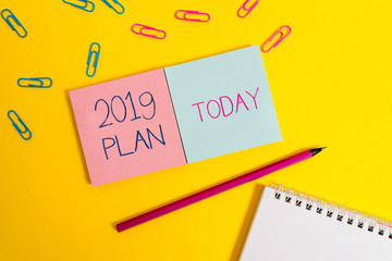 Handwriting text 2019 Plan. Conceptual photo setting up your goals and plans for the current year or in 2019 Colored square blank sticky spiral notepads pencil clips color background