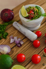 guacamole and fresh vegetables on wooden table