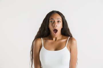 Beautiful female half-length portrait isolated on white studio background. Young emotional african-american woman with long hair. Facial expression, human emotions concept. Astonished, excited.