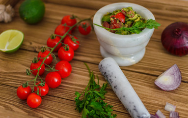 guacamole and fresh vegetables on wooden table