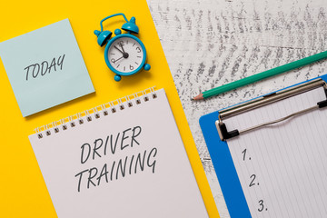 Conceptual hand writing showing Driver Training. Concept meaning prepares a new driver to obtain a driver s is license Spiral notepad sheet marker alarm clock wooden background