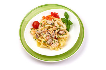 Italian Tagliatelle pasta with shrimp, shellfish and cream sauce, restaurant dish, top view, isolated on white background