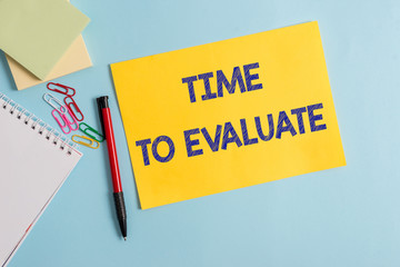 Writing note showing Time To Evaluate. Business concept for judge something with respect to its worth or significance Plain cardboard and writing equipment placed on pastel colour backdrop