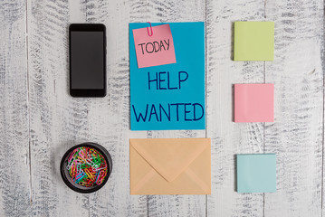 Handwriting text Help Wanted. Conceptual photo An ad in the paper an employer places to find a new employee Envelope letter smartphone note clips notepads wooden vintage background