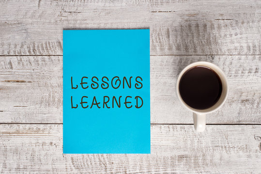 Conceptual hand writing showing Lessons Learned. Concept meaning the knowledge or understanding gained by experience Stationary placed next to a coffee cup above wooden table