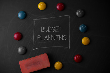 Text sign showing Budget Planning. Business photo text The written description about current and future expenses Round Flat shape stones with one eraser stick to old chalk black board