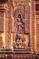 Fototapeta na wymiar Devata or Goddess carved into the red sandstone walls, Banteay Srei temple, Siem Reap, Cambodia