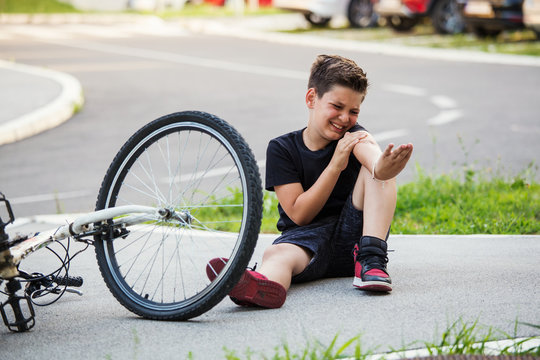 Teenage Boy There Is A Elbow Injury, As The Bike Falls While Riding. Kid Hurts His Arm After Falling Off His Bicycle. Child Is Learning To Ride A Bike