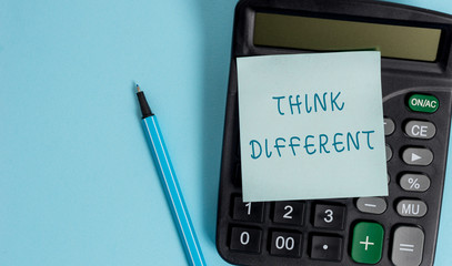 Conceptual hand writing showing Think Different. Concept meaning be unique with your thoughts or attitude Wind of change Electronic calculator sticky note marker colored background