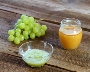 Grape face mask for natural beauty. Edible cosmetic from fresh grapes and honey on wooden board