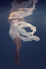 Girl in a white dress under water