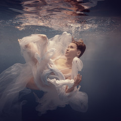 Girl in a white dress under water