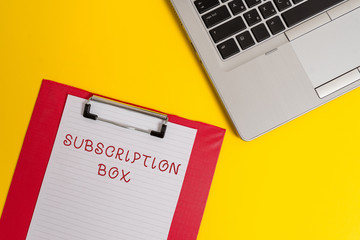 Conceptual hand writing showing Subscription Box. Concept meaning button if you clicked on will get news or videos about site Part view metallic laptop clipboard paper sheet colored background