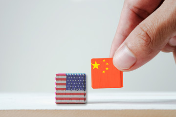 Hand putting print screen China flag and USA flag wooden cubic on white background.It is symbol of tariff trade war tax barrier between United States of America and China.-Image.