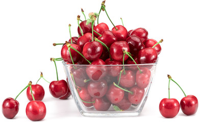 Sweet cherry in a glass plate on a white background.