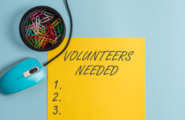 Conceptual hand writing showing Volunteers Needed. Concept meaning need work or help for organization without being paid Notebook and stationary with gadgets above pastel backdrop