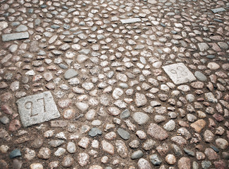In the cobbled paving of the market square are mounted stones with numbers of trading places
