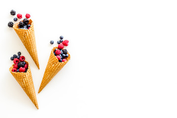 Fresh berries in waffle cones on white background top view mock up