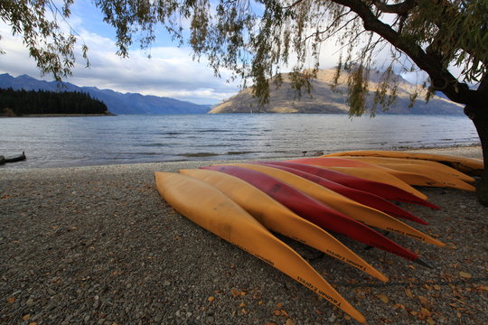 Orange kayak boat ready to go in the lake wakatipu in authumn season